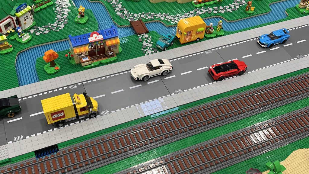 Example road in a train loop section with landscaping and vehicles.